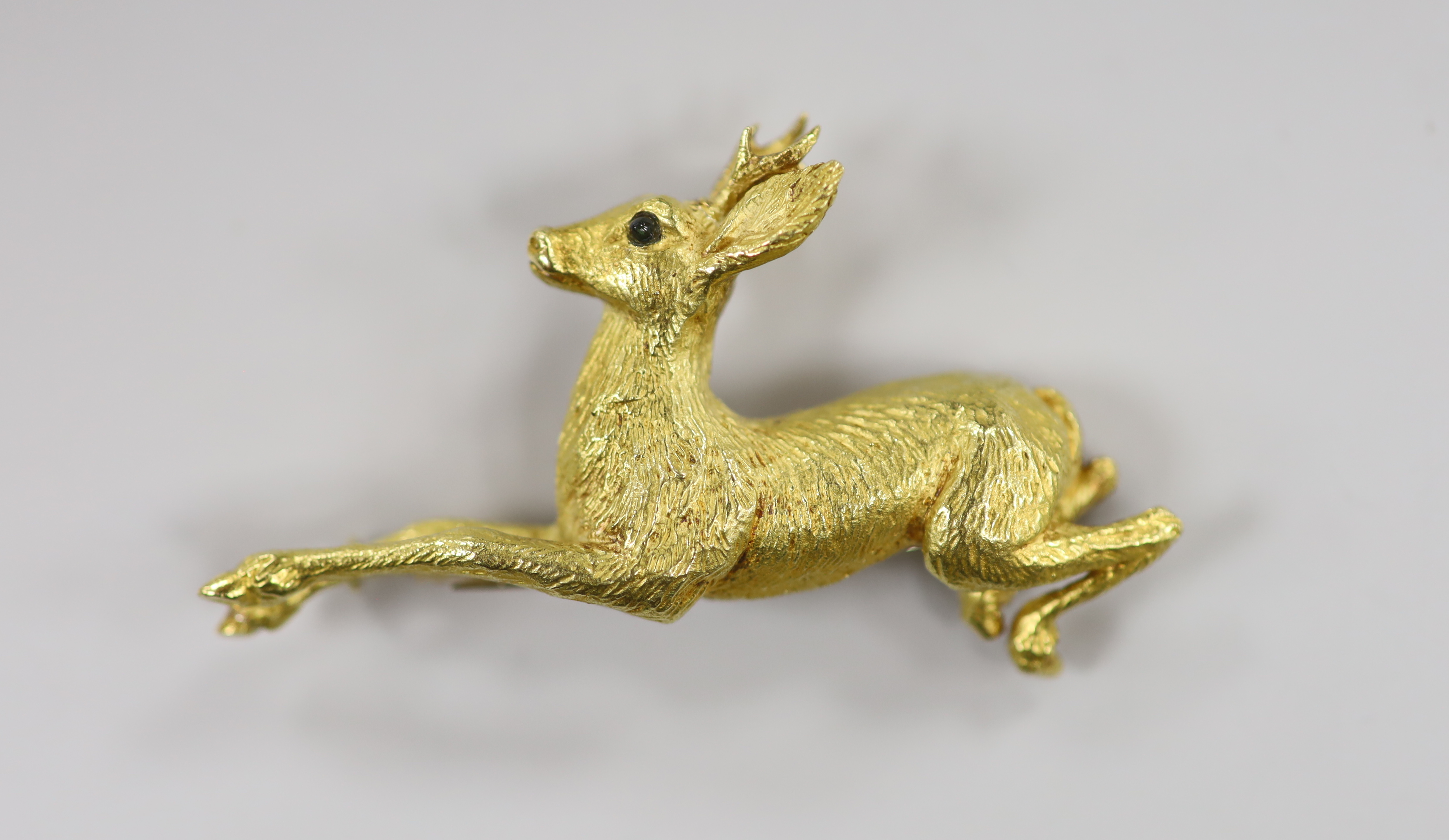 A continental textured yellow metal and gem set novelty clip brooch, modelled as a leaping deer, 55mm, 17.5 grams.